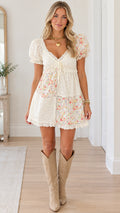 Front view of model wearing white floral patchwork puff sleeve mini dress with boots