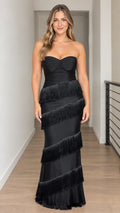 Front view of woman wearing strapless black tiered fringe maxi gown with sweetheart neckline