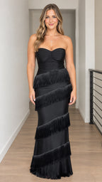 Front view of woman wearing strapless black tiered fringe maxi gown with sweetheart neckline