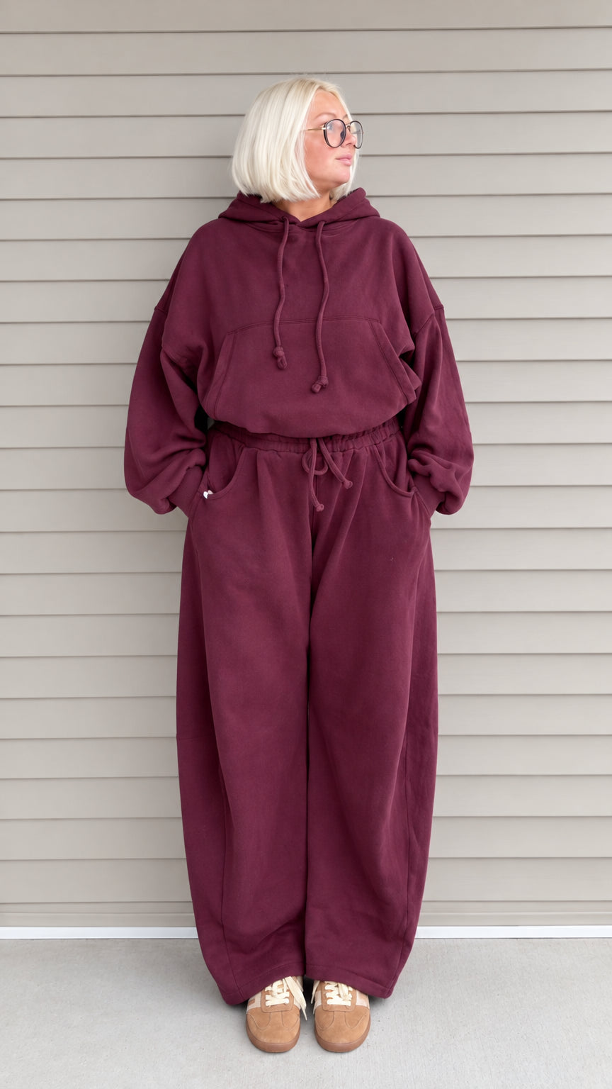 Front full-length view of woman wearing burgundy oversized hoodie and wide-leg sweatpants lounge set