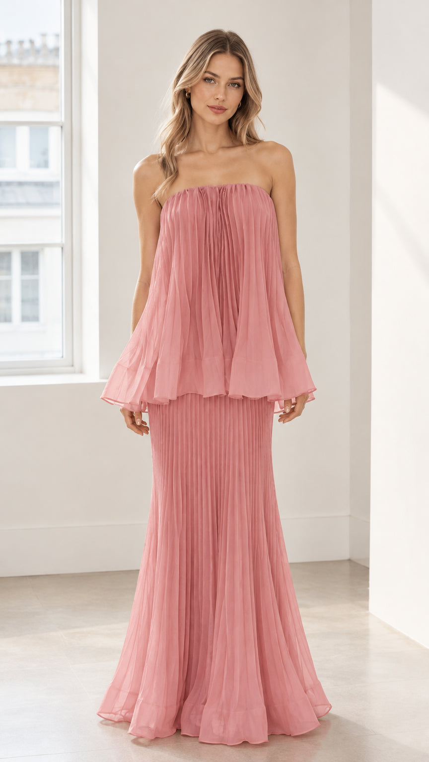 Front full-length view of model wearing dusty pink strapless pleated tiered maxi dress