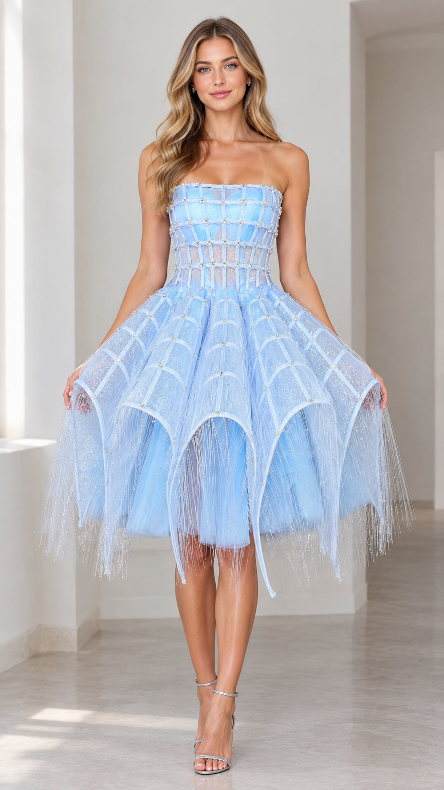 Front full view of woman wearing light blue strapless embellished grid corset dress with tiered fringe skirt