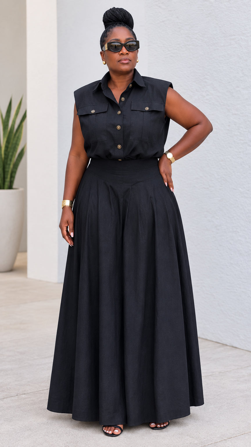 Front view of model wearing black sleeveless utility shirt and pleated wide-leg pants set