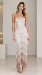 Front full-length view of model wearing champagne strapless beaded fringe tiered evening gown