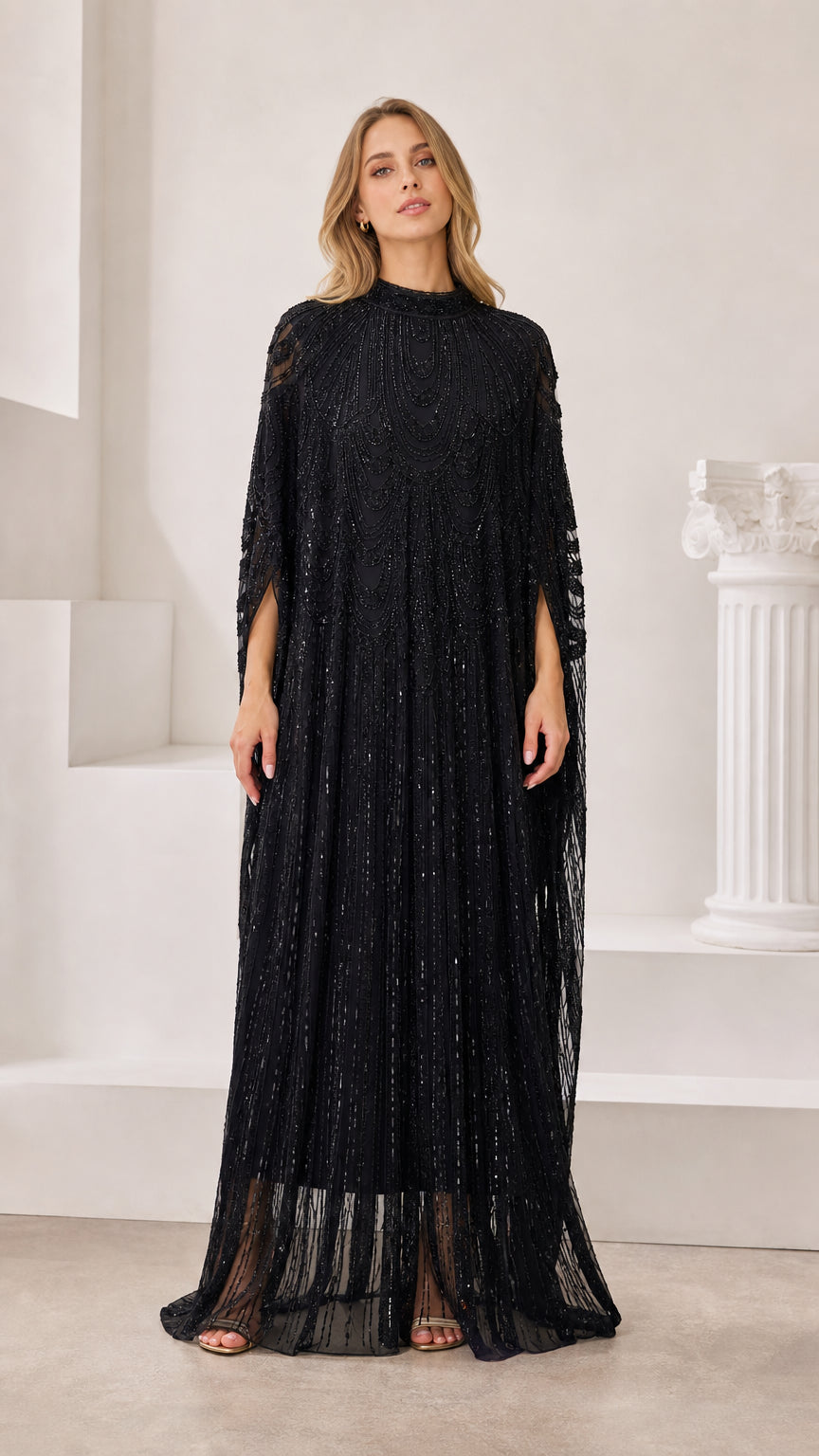 Front full-length view of model wearing black sequin cape sleeve maxi dress