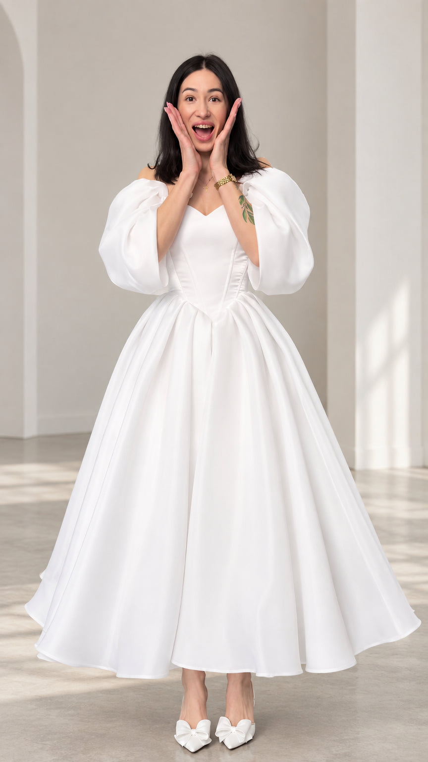Full front view of a woman wearing a white off-shoulder puff sleeve ball gown