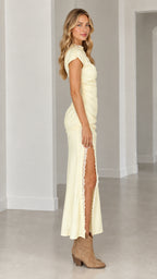 Side profile view of butter yellow lace-trim maxi dress showcasing side leg slit
