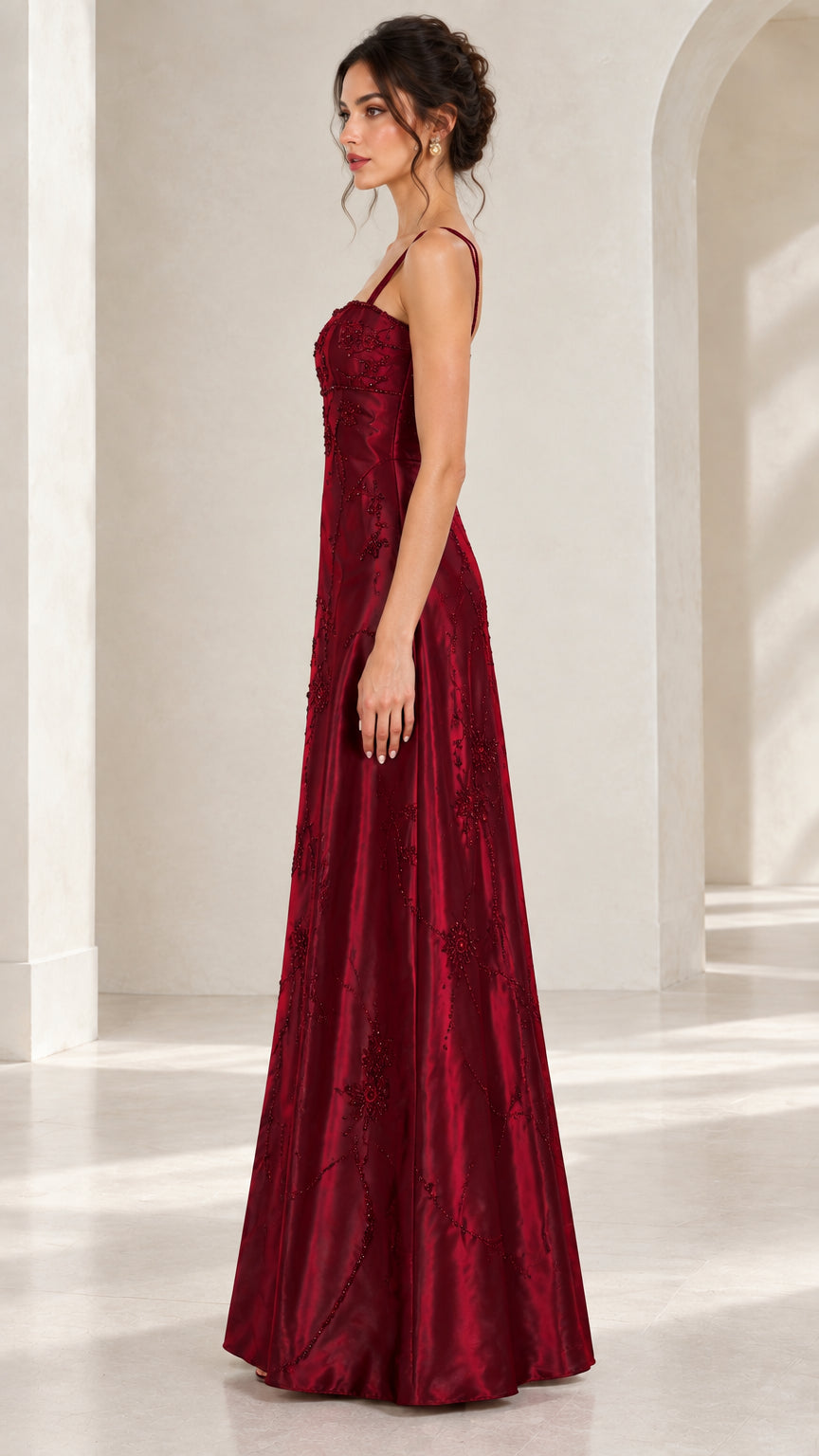 Side profile of woman modeling burgundy beaded floor-length satin evening dress