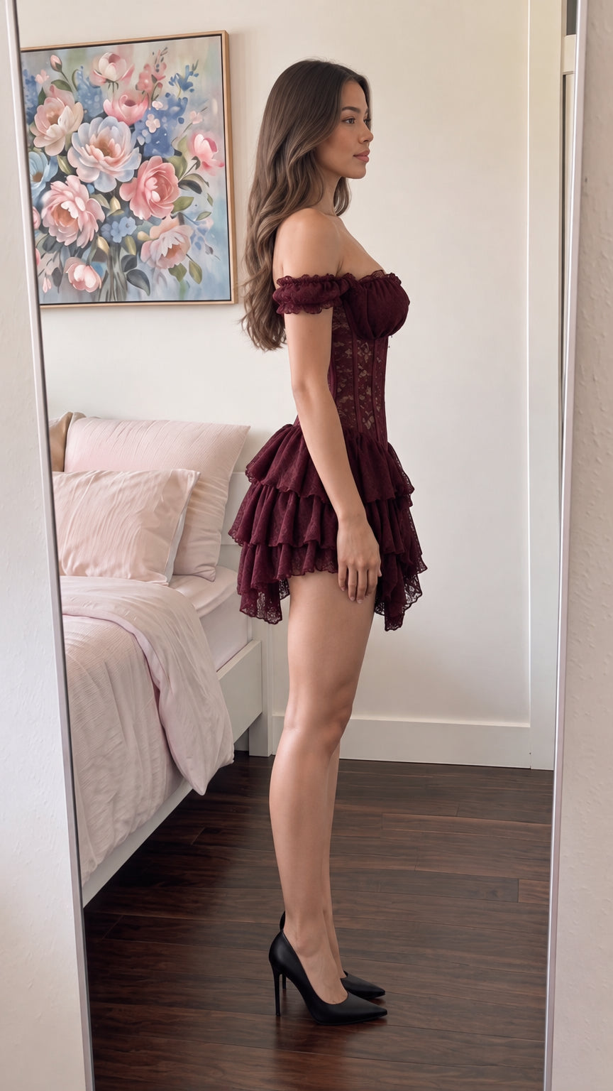 Side profile view of woman modeling the burgundy lace corset mini dress with tiered ruffle skirt