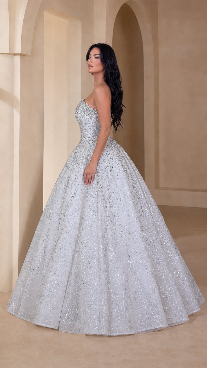 Side profile view of silver white glitter strapless ball gown with voluminous skirt