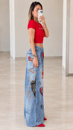 Side profile view of red cropped top and graphic wide-leg pants