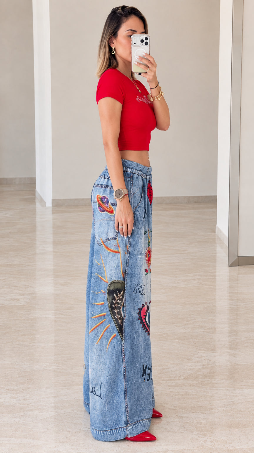 Side profile view of red cropped top and graphic wide-leg pants