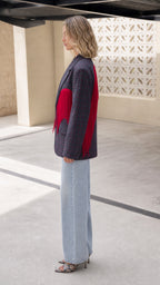 Side profile of model wearing Navy Plaid tailored blazer with red fringe accent