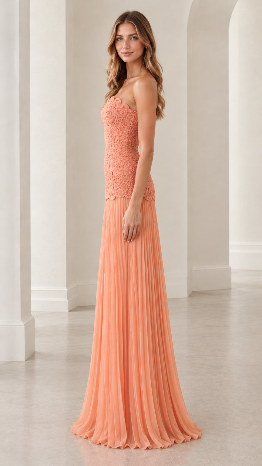Side profile view of peach strapless lace pleated maxi evening gown