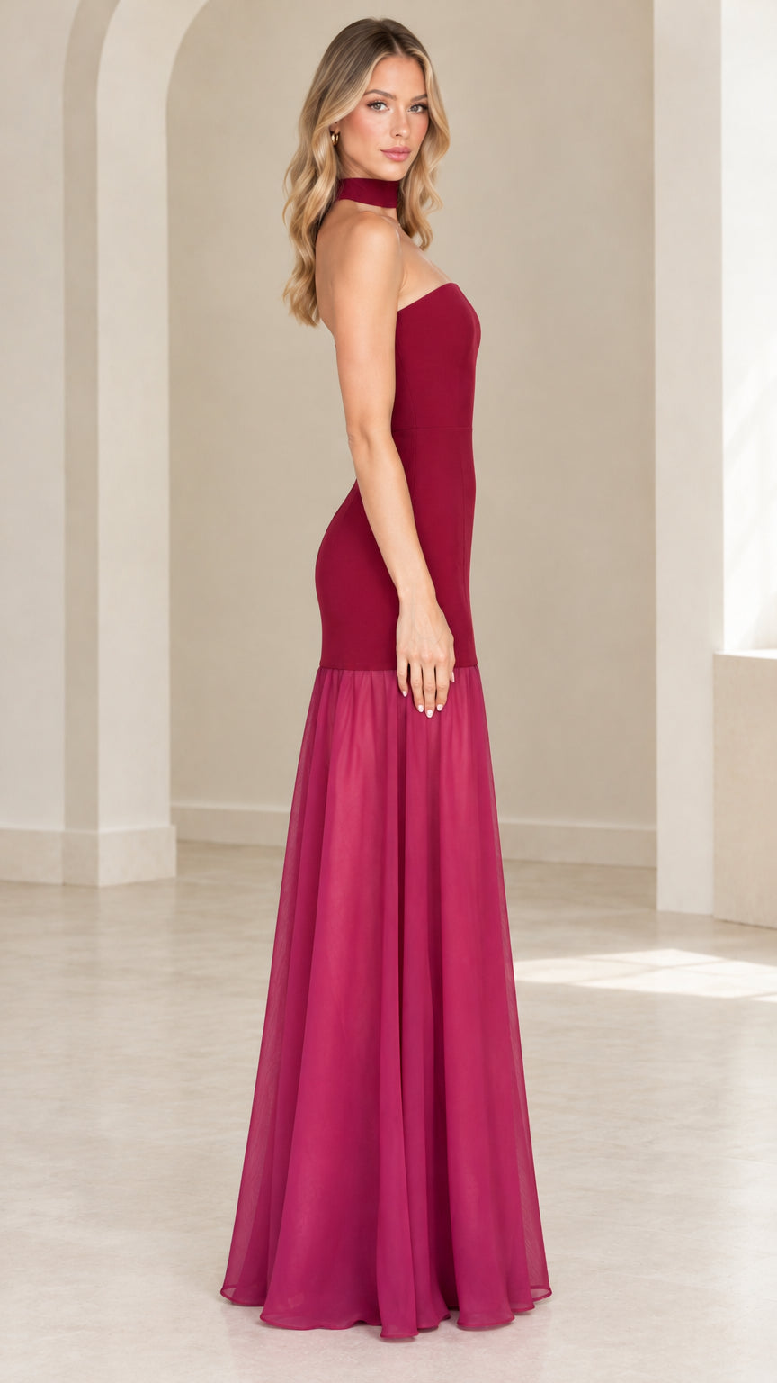 Side profile of burgundy strapless drop waist evening gown