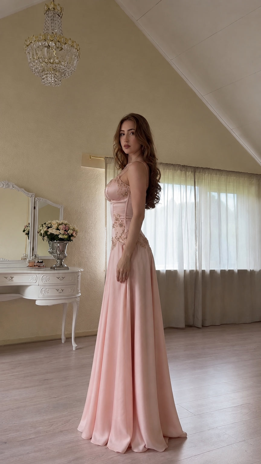 Side profile of model in pink satin evening gown with lace-up back detail
