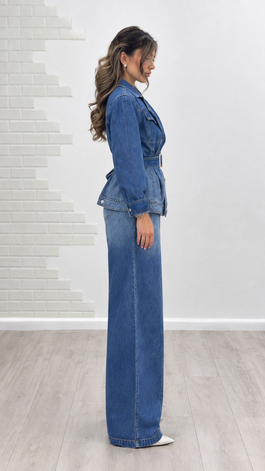 Side profile view of model wearing classic blue two-piece denim pant set