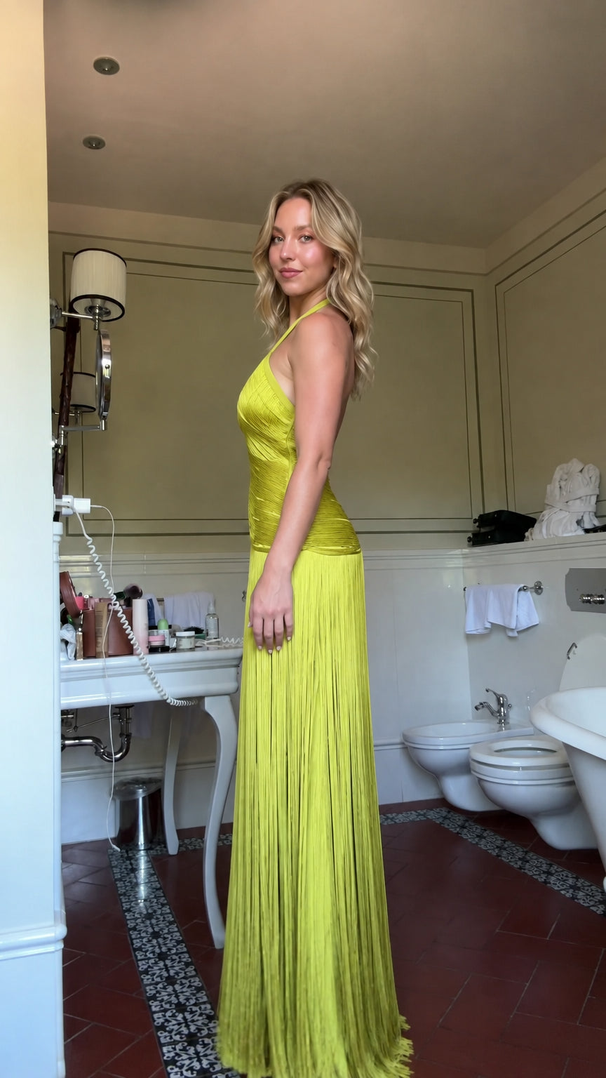 Side profile view of chartreuse pleated halter maxi gown showcasing silhouette and fit