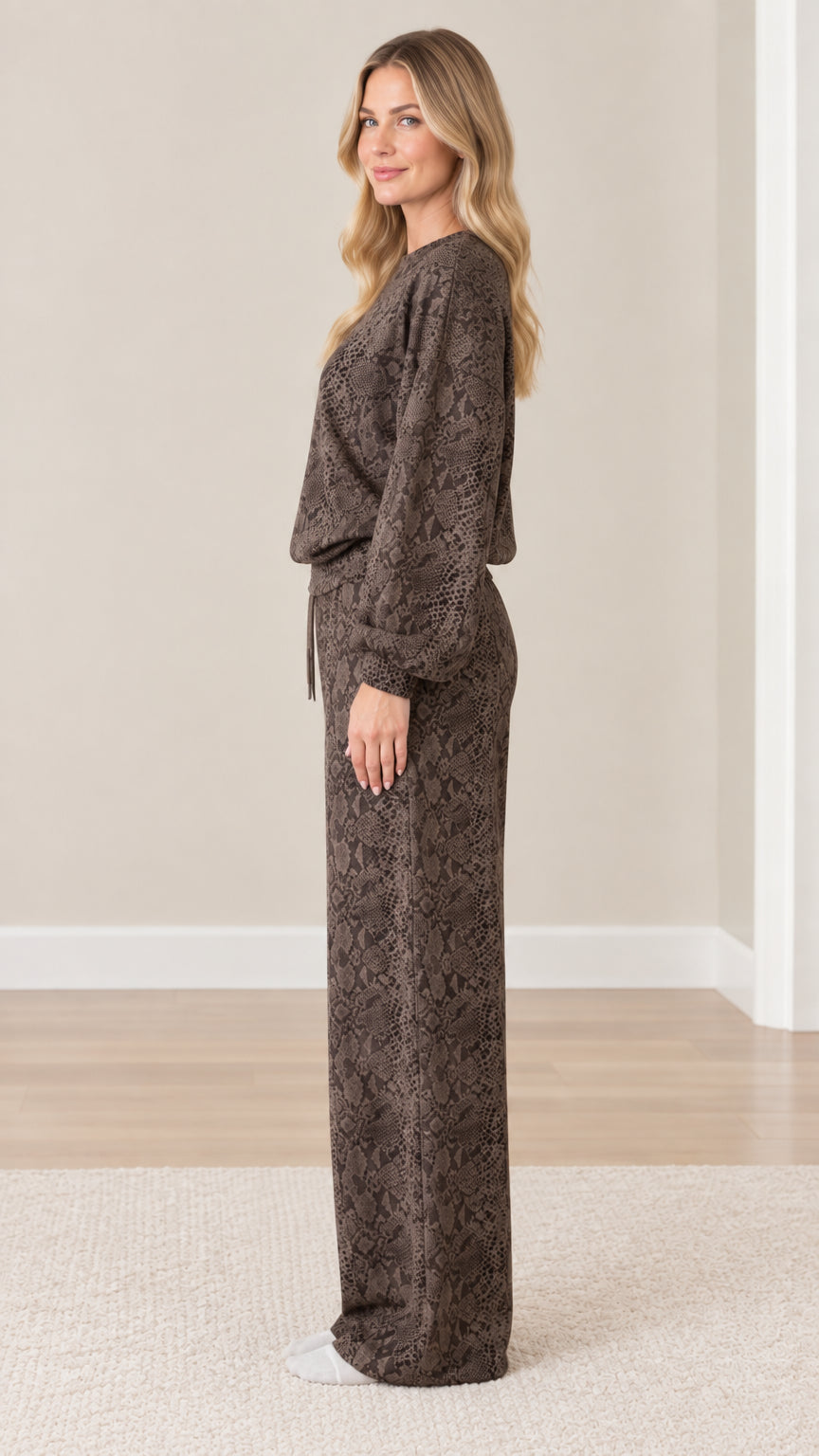 Side profile view of model wearing coordinated brown snakeskin print two-piece loungewear set