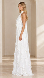 Side view of woman posing in a white floor-length tiered ruffle halter dress
