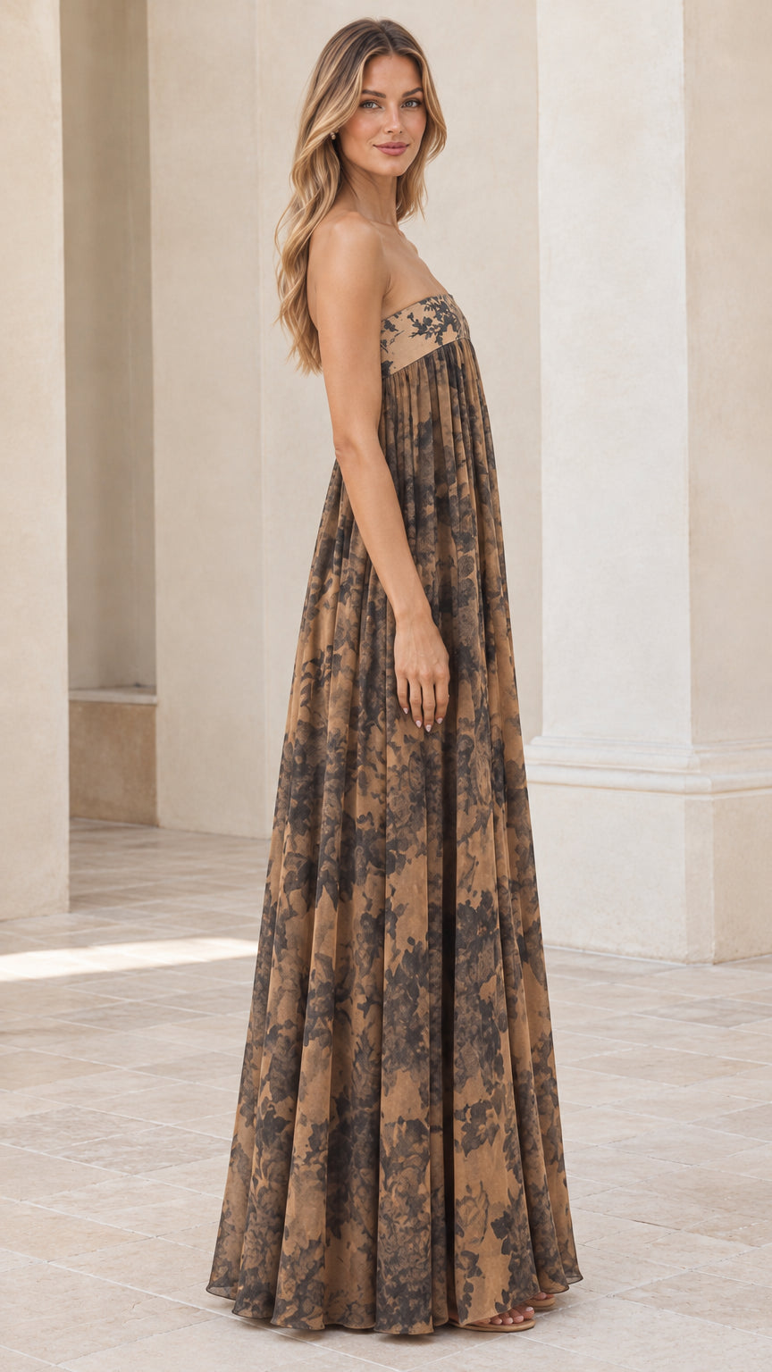 Side angle view of model in tan strapless floral maxi dress