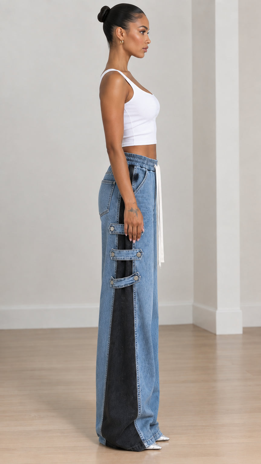 Side profile of women showing contrast side panel and metallic snap buckle straps on wide-leg jeans
