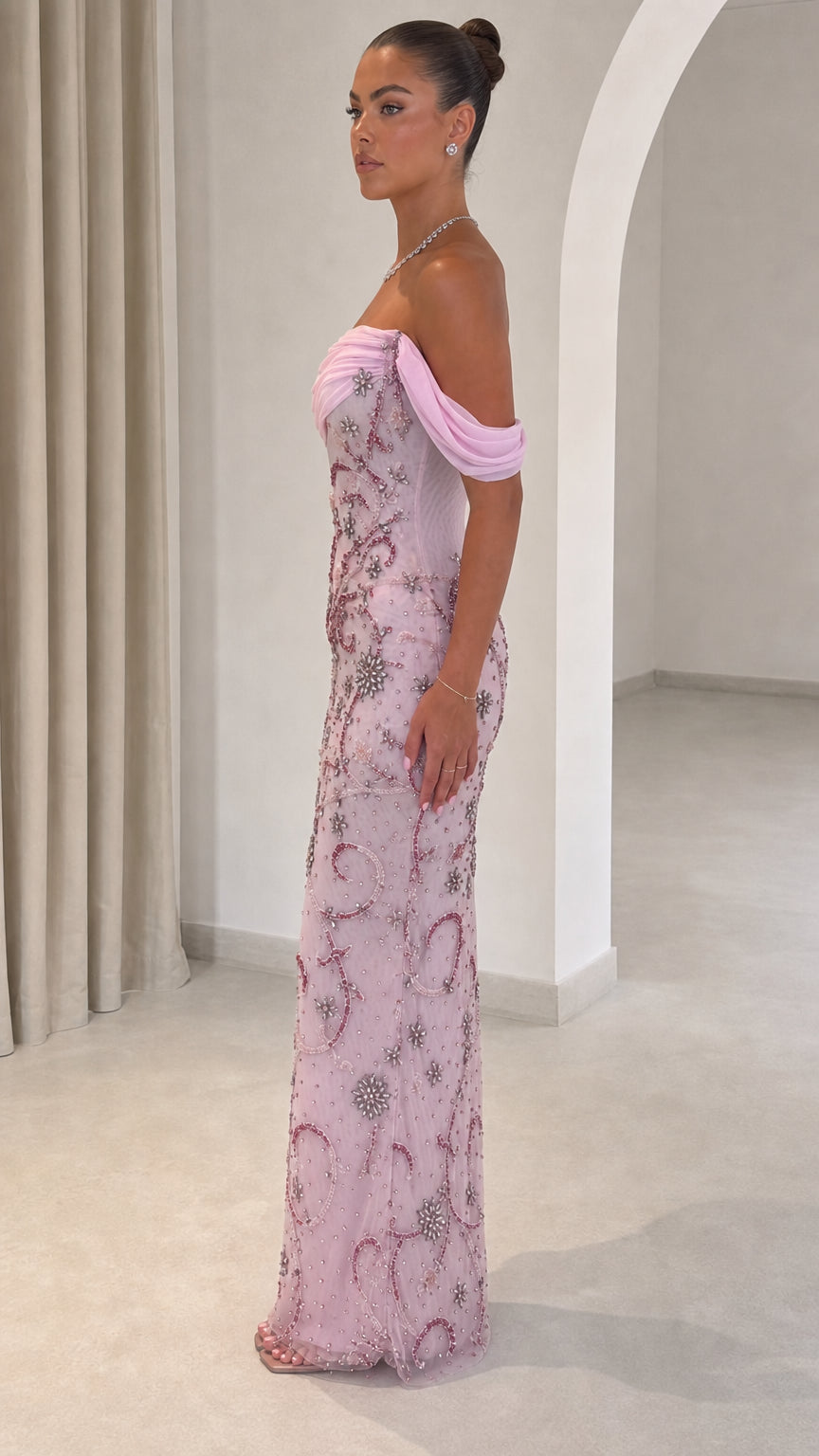 Side view of model wearing pink floor-length beaded formal dress