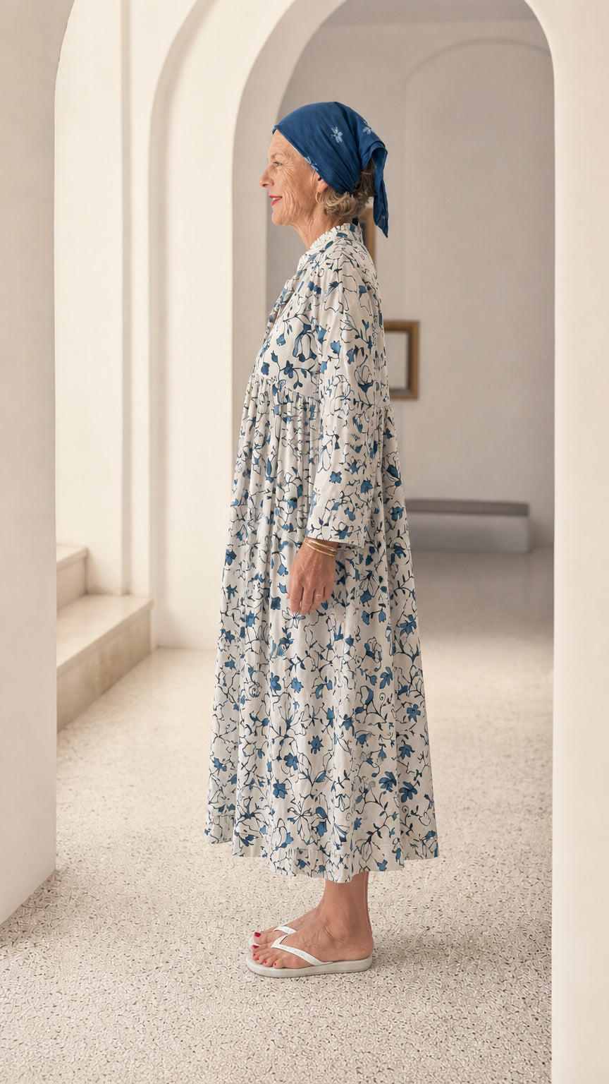 Side profile view of woman wearing Blue & White floral tiered smock dress