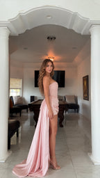 Side angle of woman wearing blush pink strapless dress with sweeping floor train