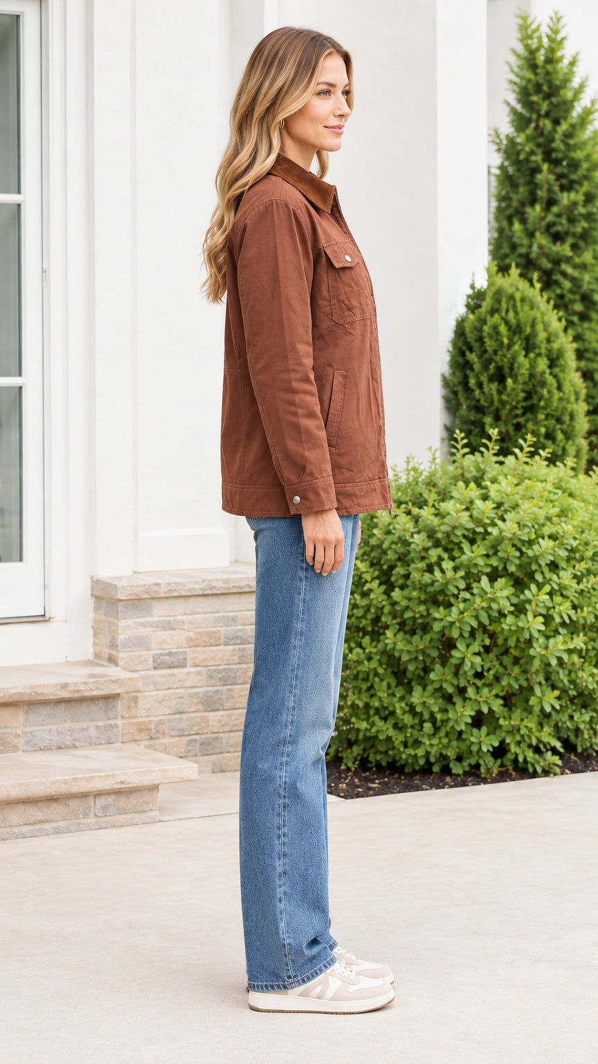 Side profile of model wearing a brown canvas utility jacket paired with blue denim jeans