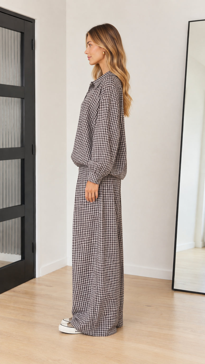 Side profile view of model wearing brown gingham two-piece pant set with sneakers