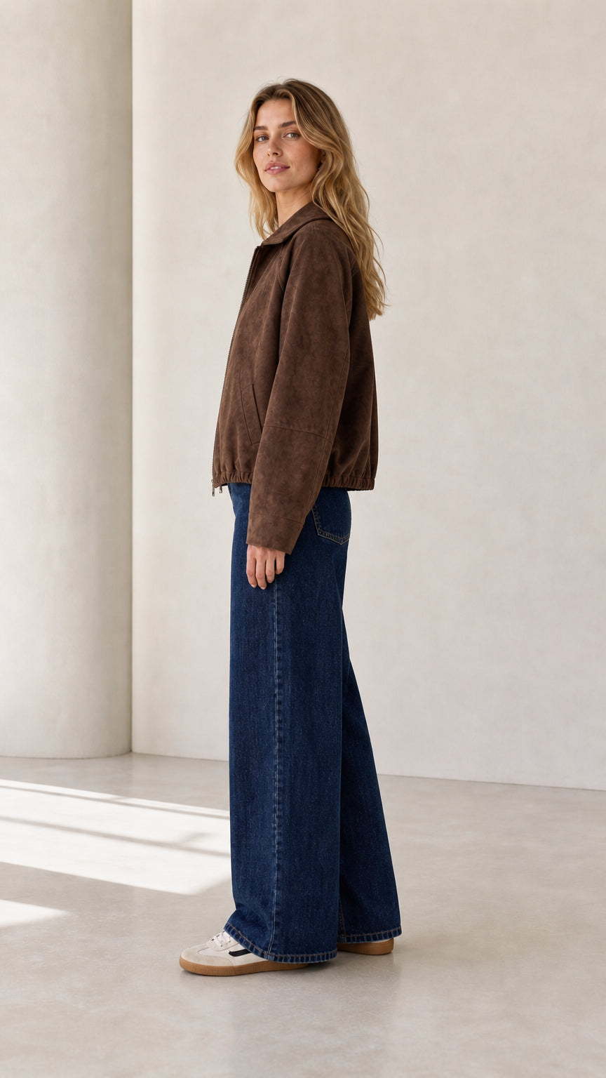 Side view of the brown cropped faux suede jacket showing its regular fit and long sleeves