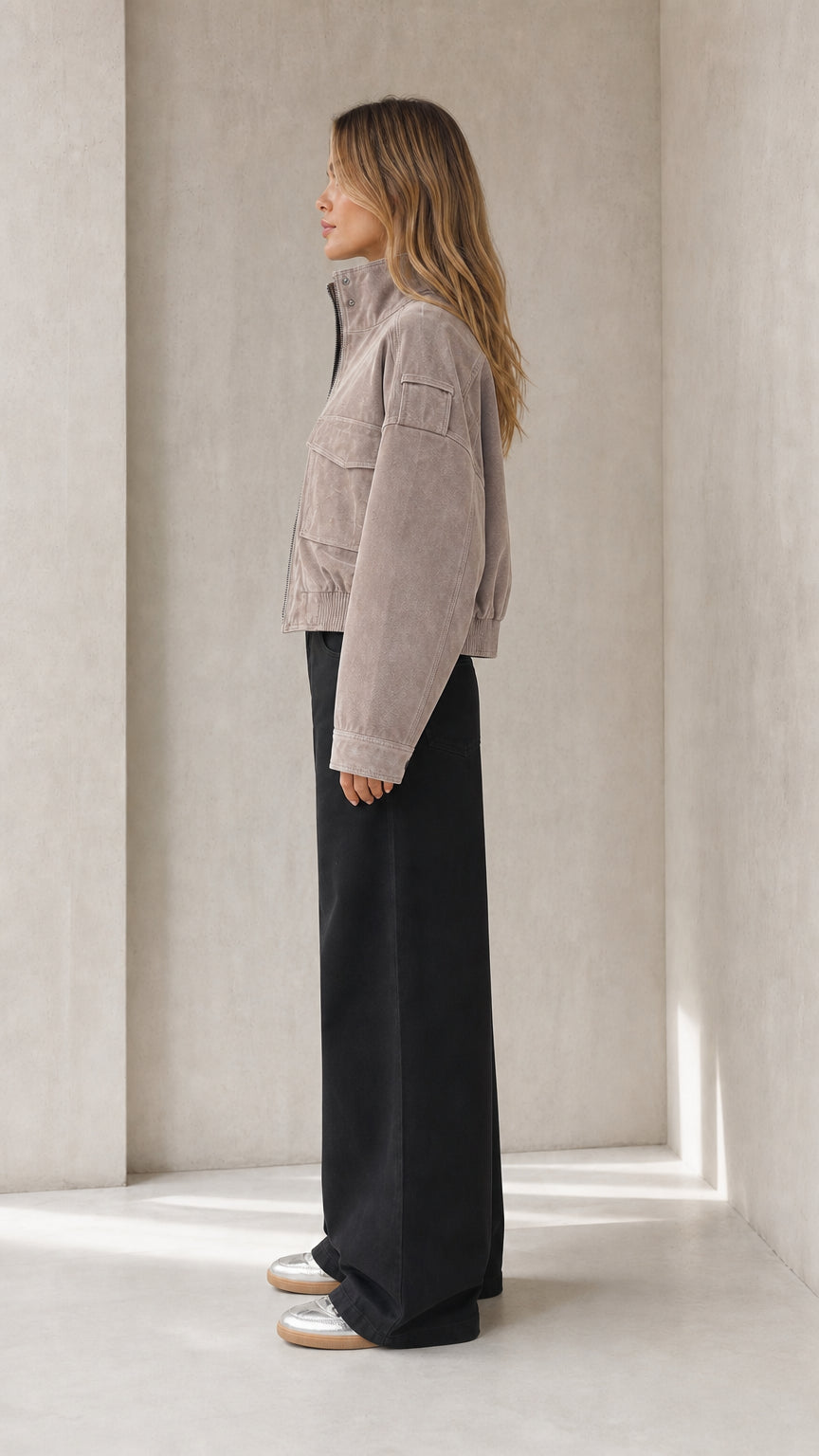 Side view of woman wearing taupe cropped cargo jacket and black wide-leg trousers