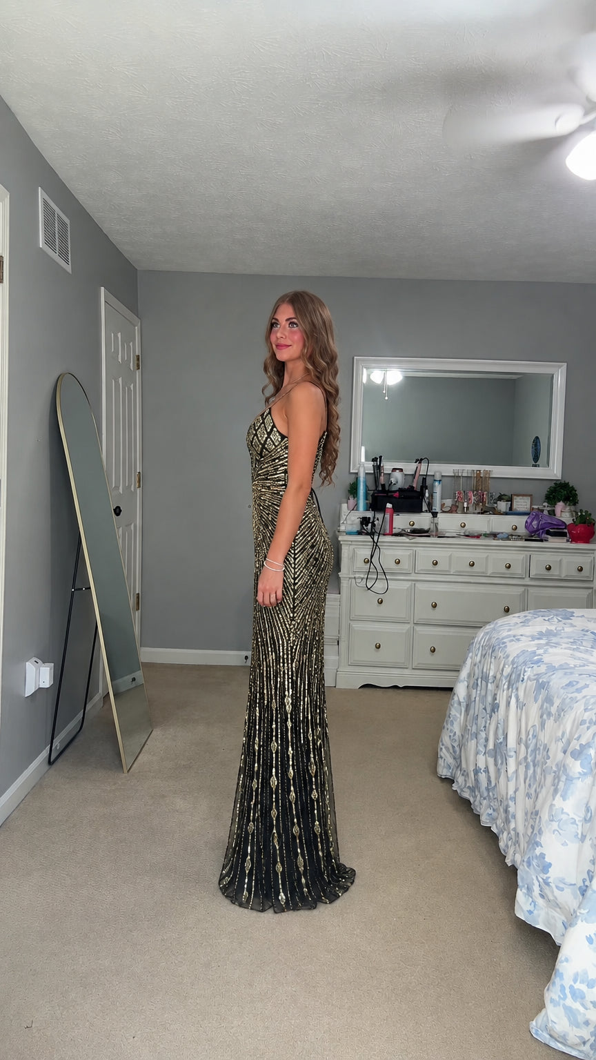 Side profile view of woman modeling the black and gold sequin formal dress