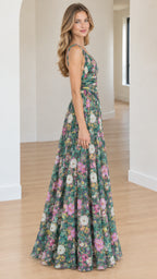 Side angle view of model posing in a floor-length green floral pleated A-line dress