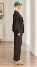 Side profile view of woman wearing charcoal knit cardigan and matching wide-leg pants