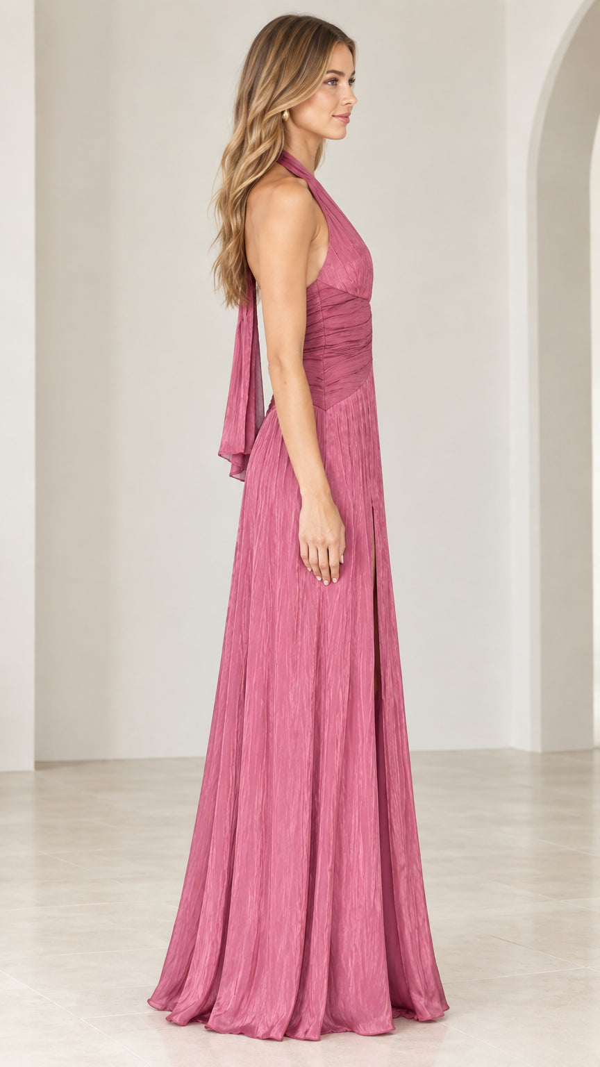 Side profile view of the rose pink pleated halter gown showing the sleek silhouette and flowing back tie