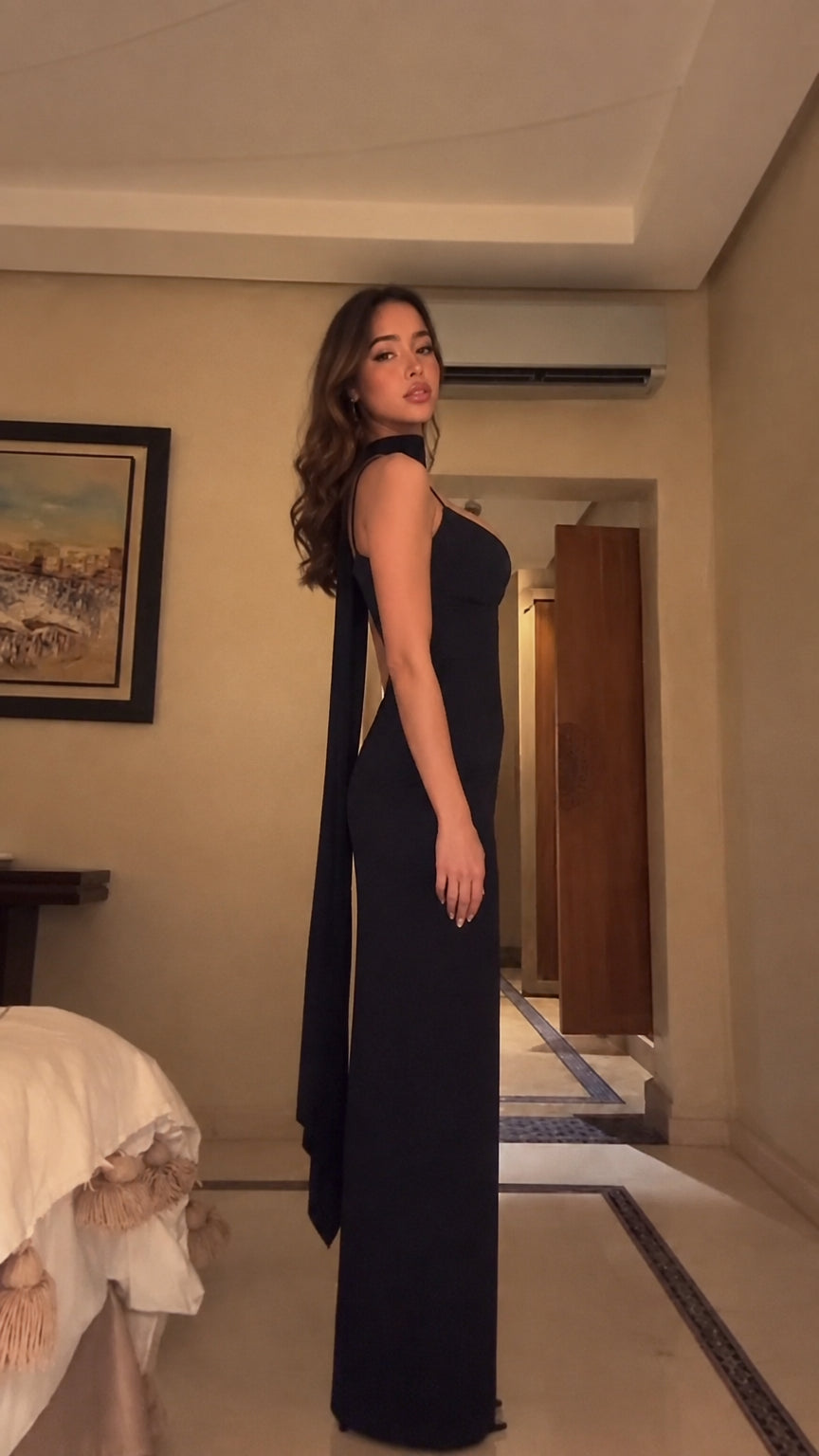 Side view of black maxi evening gown highlighting draped back scarf detail