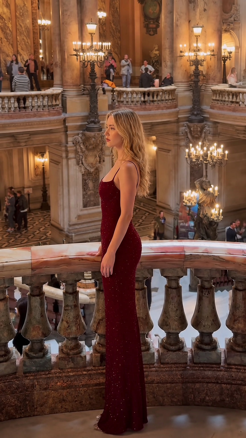 Side profile view of fitted sparkling burgundy maxi evening gown highlighting the sculpted silhouette