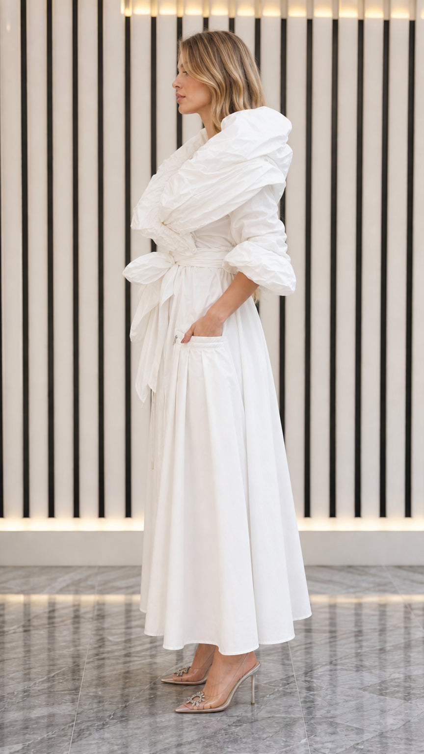 Side angle view of model in white ruched neck maxi dress with pockets