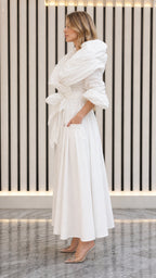 Side angle view of model in white ruched neck maxi dress with pockets