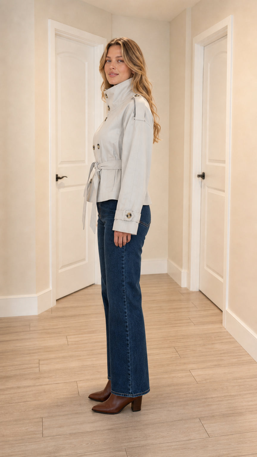 Side profile view of light grey cropped trench coat with waist tie