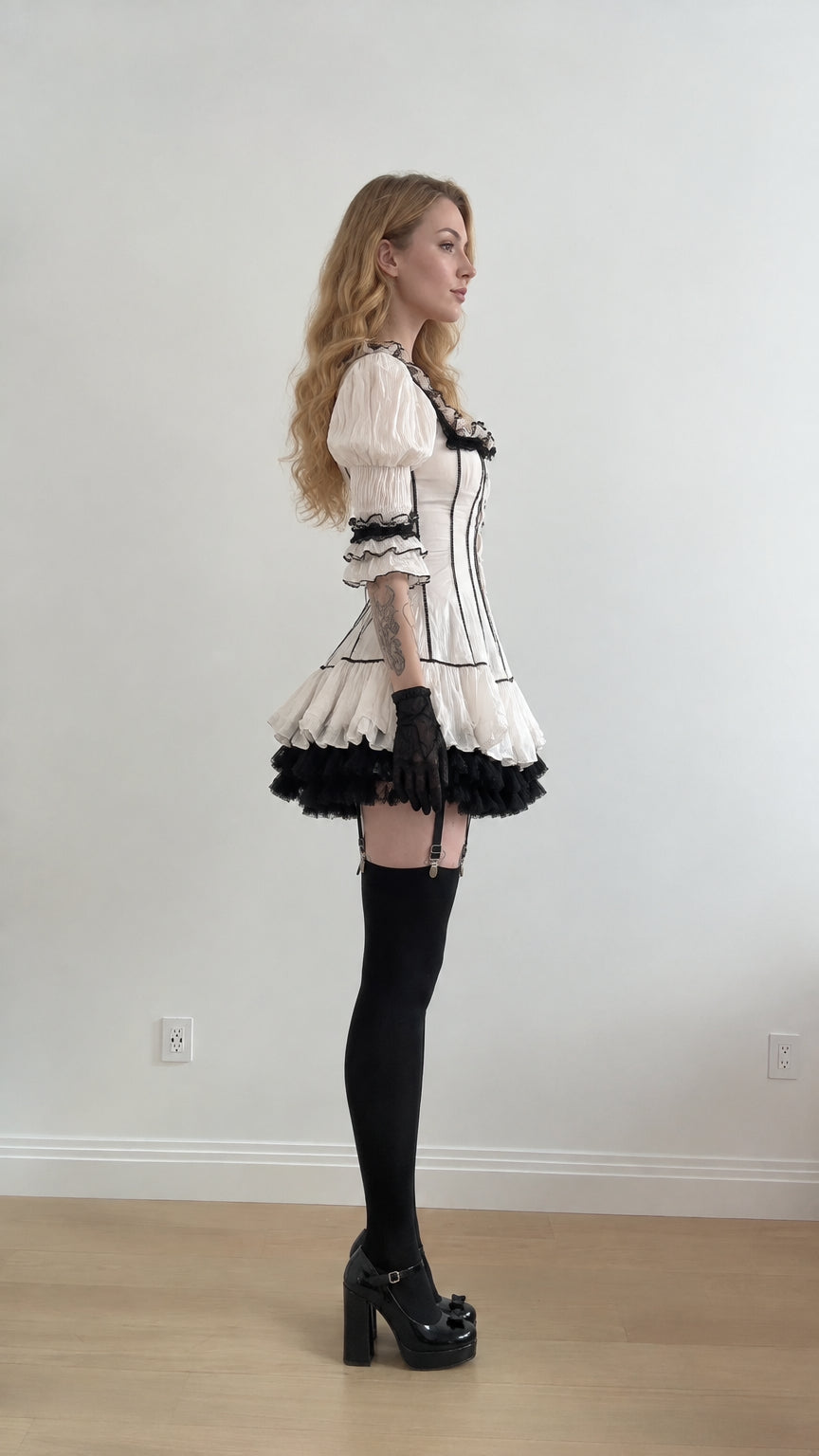 Side profile of woman in white corset-style ruffle mini dress
