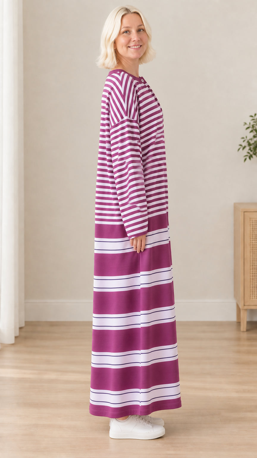 Side profile of woman wearing purple striped long sleeve maxi dress