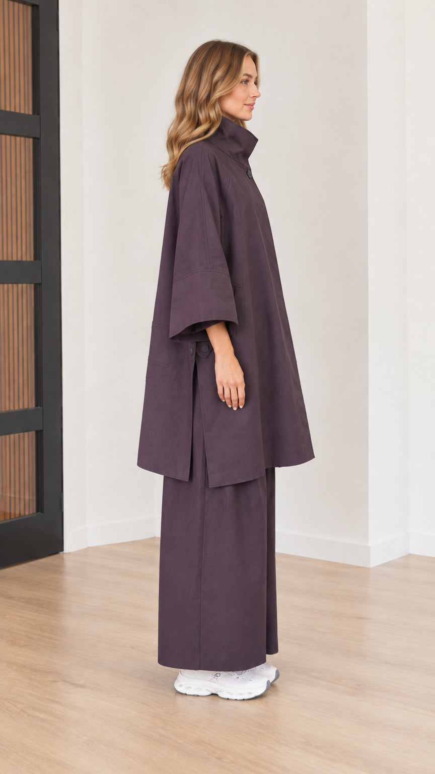 Side profile view of women's relaxed eggplant high-neck tunic and matching wide-leg trousers