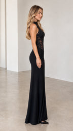 Side profile of model wearing black sleeveless formal lace evening gown
