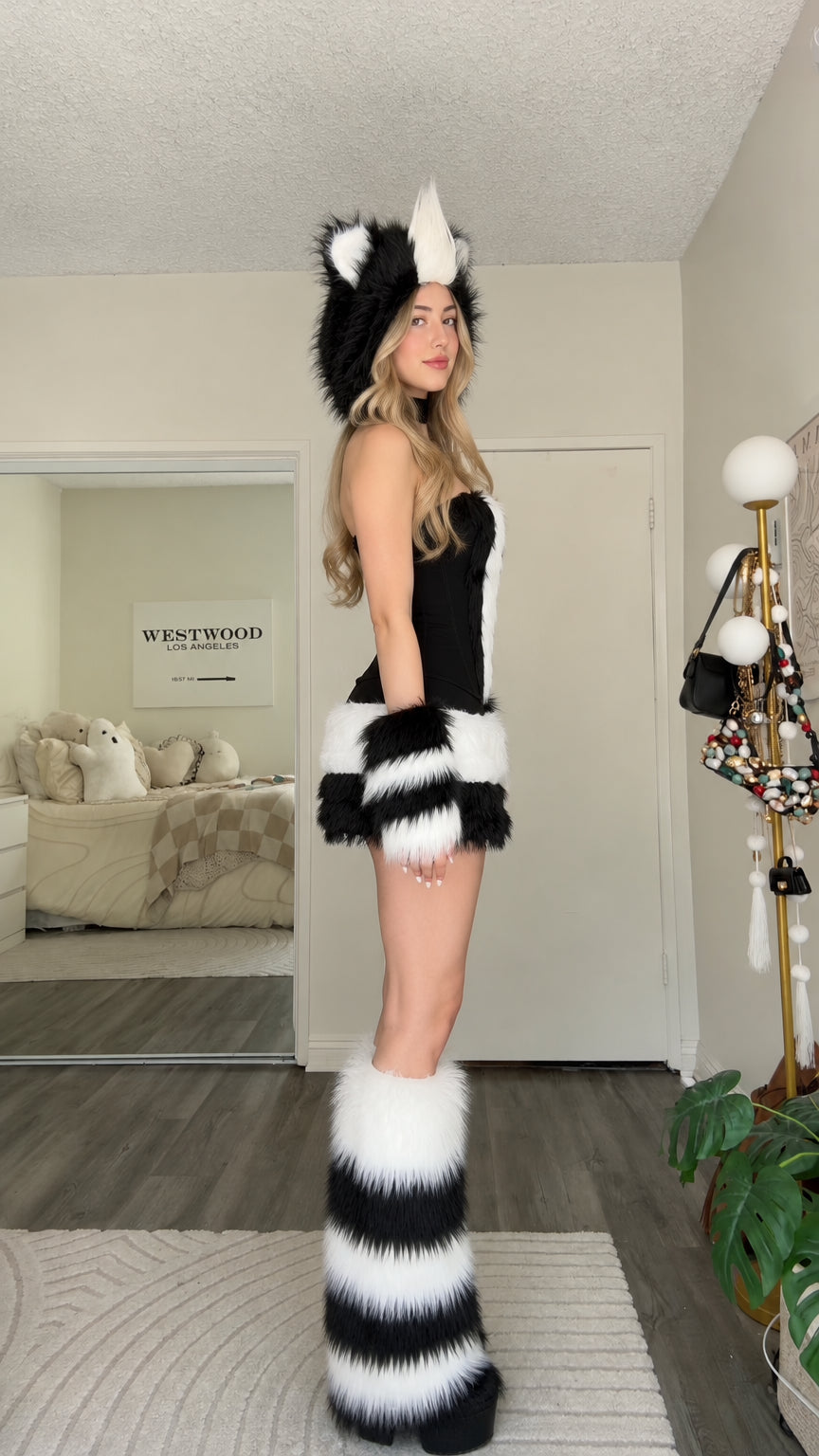 Side profile view of black and white animal costume dress with plush accessories