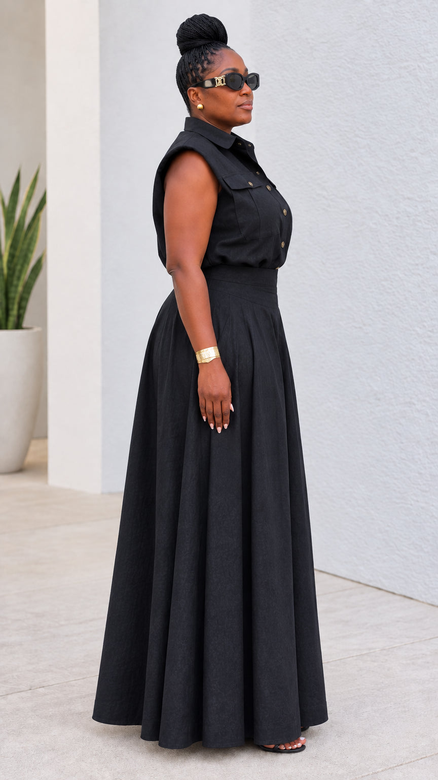 Side profile of model in black sleeveless top and high-waisted wide-leg maxi pants