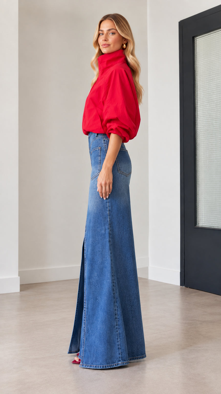 Side profile of woman wearing red zip jacket and dramatic flared slit denim trousers
