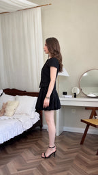 Side profile of model wearing black tweed matching skirt set